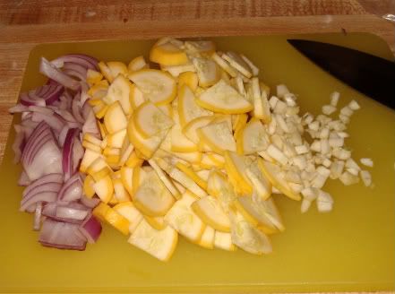 red onion, yellow squash, and two cloves of garlic ready to cook